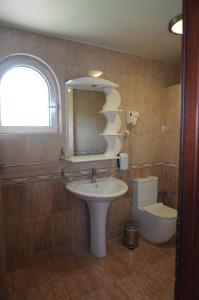 a bathroom with a sink and a mirror and a toilet at Konačište Compass in Kraljevo +1 photo