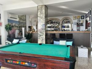 a room with a pool table and a bar at Hotel Rocamar in Cala Figuera