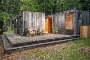 a wooden deck with a table and chairs on it at Nature's Nest - The Woods in Maribor +10 photos