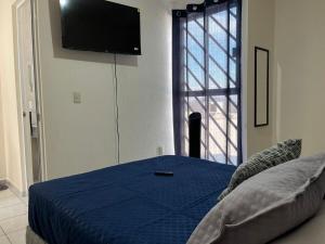 a bedroom with a bed with a tv on the wall at Residencial Granate Xochitepec Morelos in Atlacholoaya