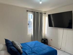 a bedroom with a bed with a television on the wall at Residencial Granate Xochitepec Morelos in Atlacholoaya