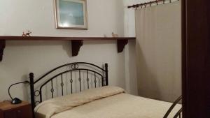 een slaapkamer met een bed en een plank aan de muur bij Holiday Home Golfo di Orosei Cala Gonone in Cala Gonone