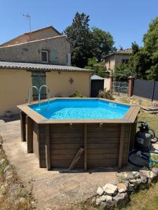 a pool with a wooden deck and a swimming pool at Gîte de Fertés in Amarens