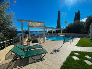 a pool with chairs and a gazebo at Oasis Boutique Hotel in Nydri