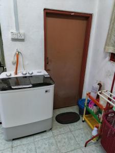 a kitchen with a stove and a door at Homestay Rumah Inap ABC Semi-D in Pasir Mas