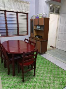 a dining room with a table and chairs and a microwave at Homestay Rumah Inap ABC Semi-D in Pasir Mas