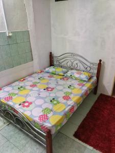 a small bed in a room with a flower pattern at Homestay Rumah Inap ABC Semi-D in Pasir Mas +7 photos