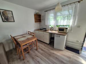 a small kitchen with a table and a microwave at Noclegi u Loni - Szary domek - noclegi w zacisznym centrum Pobierowa nad morzem z parkingiem in Pobierowo