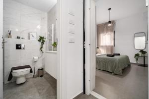 a white bathroom with a toilet and a bed at   +93 photos