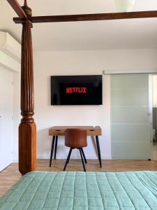 a bedroom with a desk and a television on the wall at Zimmer Room Trogir Kastela Split in Kaštela