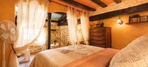 a bedroom with a bed and a dresser and a window at La Casa del Ayer in Ábalos