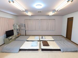 a room with two beds and a flat screen tv at Big Island Base 一組限定の庭付き一棟貸し BBQ 焚き火 テントサウナ 最大6名 in Oshima