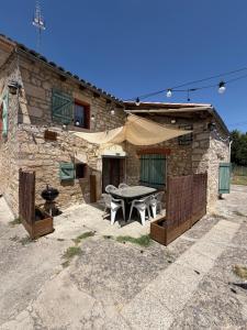 a stone house with a picnic table in front of it at Gîte de Fertés in Amarens