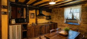 a kitchen with a wooden table in a room at La Casa del Ayer in Ábalos