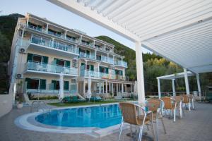 a hotel with a pool and chairs and a building at Oasis Boutique Hotel in Nydri