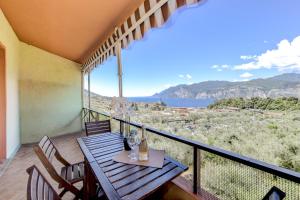 a balcony with a wooden table and chairs with a view at Residence Kormorano Malcesine Apt 52 in Malcesine