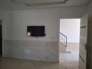 a living room with a flat screen tv on a wall at Palm Serenity in Tangier