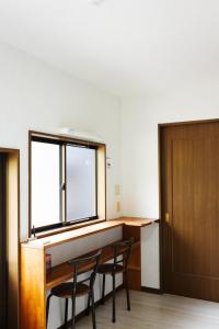 a room with a table and chairs and a window at Big Island Base 一組限定の庭付き一棟貸し BBQ 焚き火 テントサウナ 最大6名 in Oshima +13 photos