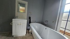 a bathroom with a tub and a sink and a mirror at Kings Place Montagu in Montagu