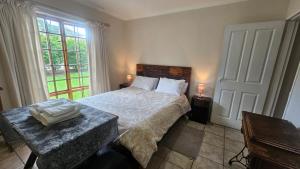 a bedroom with a bed and a large window at Kings Place Montagu in Montagu