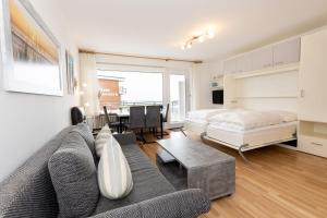 a living room with a couch and a bed at Hanseatic 204 in Duhnen +21 photos