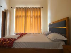 a bedroom with a large bed with a window at Hotel Aditya in Dharāsu