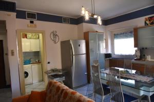 a kitchen with a refrigerator and a table with chairs at appartamento Macchia in Agropoli