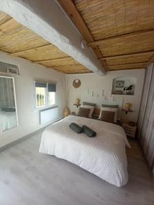 a bedroom with a white bed and a wooden ceiling at Charmante chambre d'hôtes "CARLA" avec piscine, Château de Favas in Bargemon