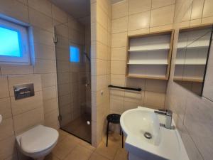 a bathroom with a toilet a sink and a shower at Noclegi u Loni- pokoje studio w zacisznym centrum nad morzem z parkingiem in Pobierowo +57 photos