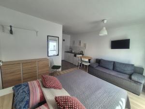 a bedroom with a bed and a couch at Noclegi u Loni- pokoje studio w zacisznym centrum nad morzem z parkingiem in Pobierowo
