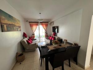 a living room with a table and a couch at Beachside Garden Apartment in Marina Smir in Marina Smir