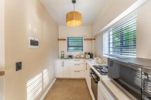 a kitchen with white cabinets and a large window at Eden on Walton 1 in Sea Vista