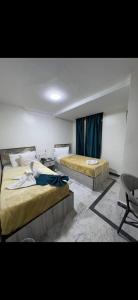 a room with two beds and a chair in it at Osiris Cairo Hotel Downtown in Cairo