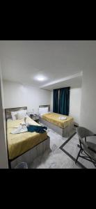 a bedroom with two beds and a table and chairs at Osiris Cairo Hotel Downtown in Cairo