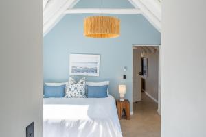 a bedroom with a white bed with blue pillows at Eden on Walton 1 in Sea Vista +15 photos
