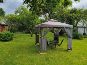 a gazebo with a table and chairs in a yard at Lerihouse in Saulkrasti +10 photos