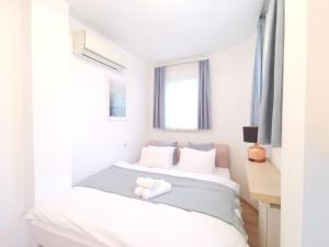 a white bedroom with a bed and a desk at Hillside Apartment with AC & heating in Grande Maison in Budapest
