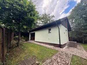 a small white house with a tree and a yard at Chalet-Širava in Vinné