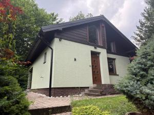a small white house with a black roof at Chalet-Širava in Vinné +5 photos