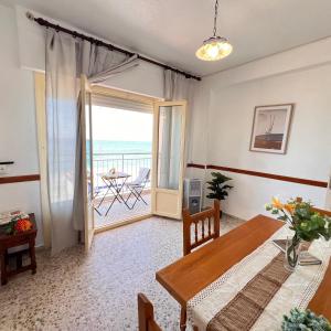 a dining room with a table and a balcony at Todimer Acera del Mar in Torrenueva