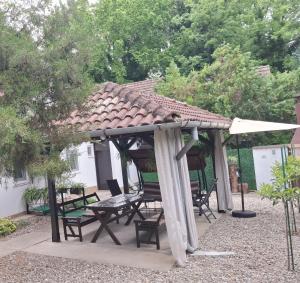 a wooden gazebo with a table and chairs at Palić Libero Apartman in Palić +84 photos