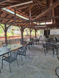 a patio with tables and chairs in a building at Pension Assos in Koinyra
