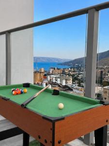 a pool table on a balcony with a view at Kinneret Royal Penthouse in Tiberias