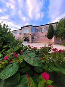 a building with a bunch of flowers in front of it at STOP otel in Sheki