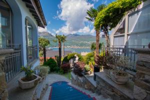 a house with a pathway with plants and a view of the water at Albergo Ristorante Conca Azzurra in Colico