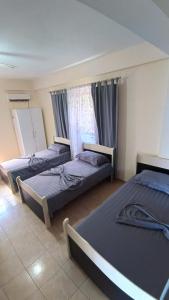 a room with three beds and a window at ℰ`ℋ Hotel - Velipoje rruga nr 7 in Velipojë