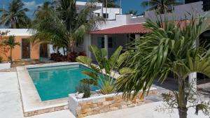 a swimming pool in front of a house with palm trees at Private Pool, Beach Access 3BR Sleeps 6 in Chelem