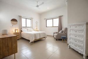 a bedroom with a bed and a chair at Private Pool, Beach Access 3BR Sleeps 6 in Chelem +34 photos