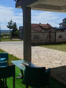 a patio with a table and chairs and a stone wall at Hostel JAPI in Aleksinac