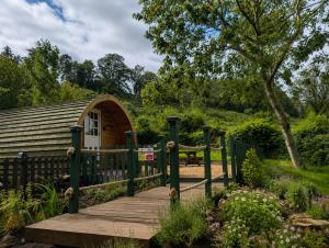 a wooden boardwalk leading to a garden with a building at Caplor Glamping & Lodges in Hereford